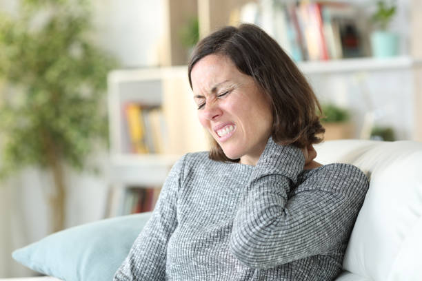 volwassen vrouw die pijnlijke nechacke thuis lijdt - menselijke nek stockfoto's en -beelden