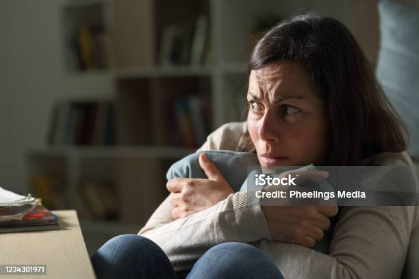 Scared Middle Age Woman Looking Away At Night At Home Stock Photo - Download Image Now