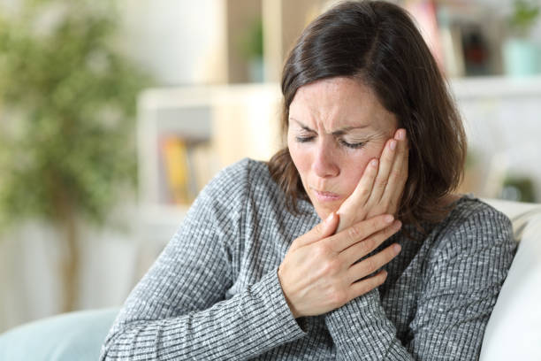 Middle age woman suffering toothache at home Middle age woman suffering toothache at home abscess stock pictures, royalty-free photos & images