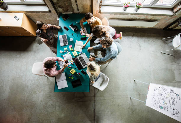 istock Above view of multi-tasking creative team working in the office. 1224302928