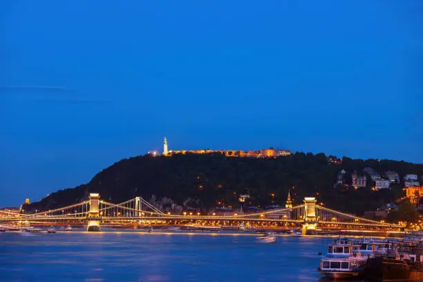 Gellert Hill with Citadel in Budapest at night, illuminated bridges on Danube river, capital city of Hungary
