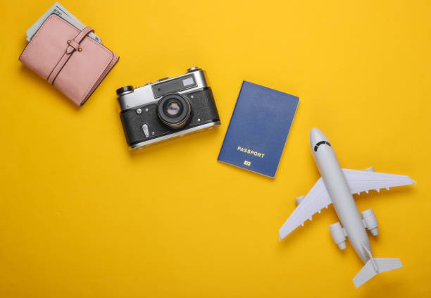 istock Flat lay travel composition on yellow background. Plane figurine, passport, wallet with dollars, camera. Recreation, vacation and tourism, minimalism concept. Top view 1224303349