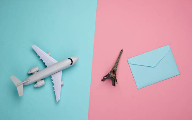 istock Flat lay travel composition. Plane figurine, statuette of the Eiffel tower and envelope on a blue-pink pastel background. Top view 1224303506