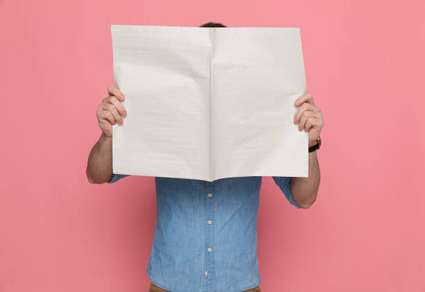 istock casual guy hiding his face from camera behind a newspaper 1224304581