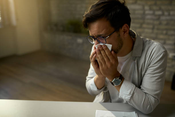 istock Sick freelance worker blowing nose while working in the office. 1224305829