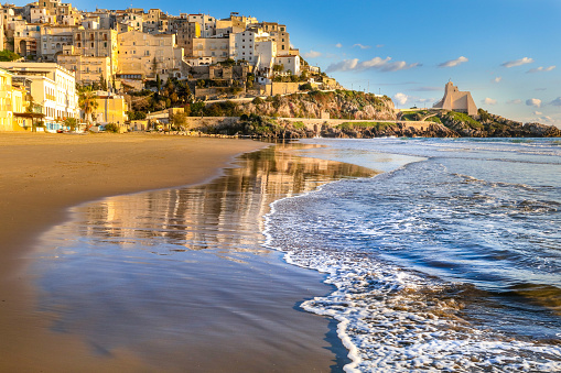 Sperlonga, Italy -- A sunset view of the city of Sperlonga, in the south of Rome, perched on a rocky outcrop facing the Tyrrhenian Sea. Sperlonga was founded by the Romans and became the site of numerous imperial villas, including the famous villa of Emperor Tiberius, whose archaeological remains are still preserved today. Sperlonga is a very popular place in summer for its beautiful and peaceful beaches.