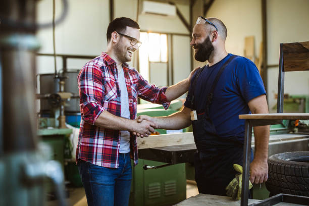 istock Happy customer and manual worker shaking hands in a workshop. 1224306128