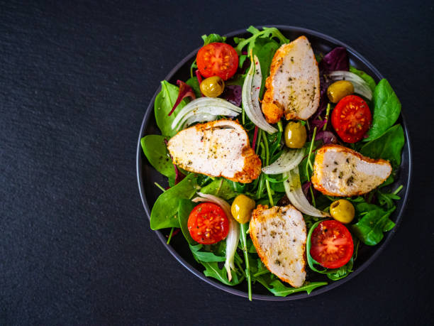 caesar salad  - vegetable salad with roast chicken meat on wooden background - chicken salad grilled chicken grilled imagens e fotografias de stock