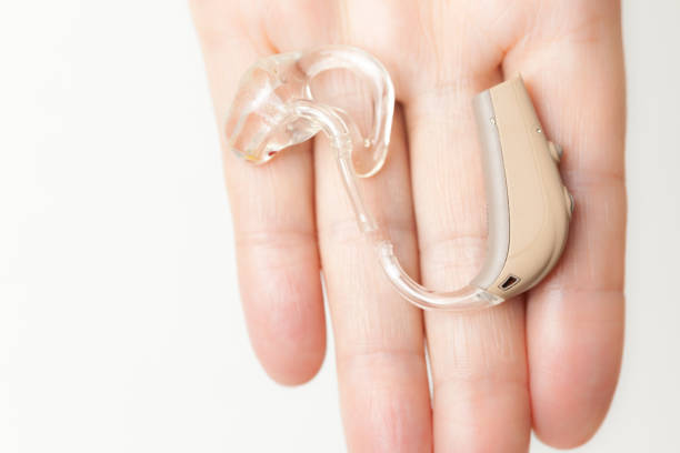 istock senior person holding hearing aid closeup 1224308468