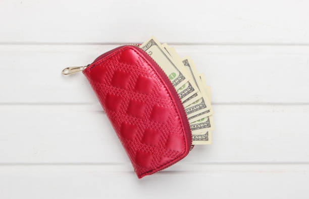 istock Red wallet with hundred dollar bills on white wooden background. Top view 1224308961