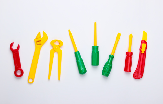Set of children's toy work tools on a white background. Top view
