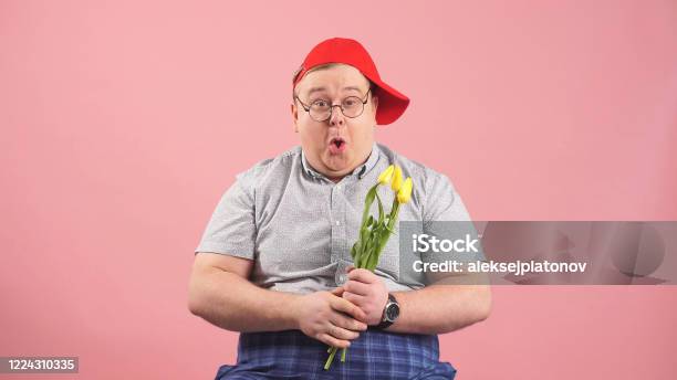 Funny Man Who Looks Very Much Like Winniethepooh With Yellow Tulips In His Hands On An Isolated Pink Background Stock Photo - Download Image Now