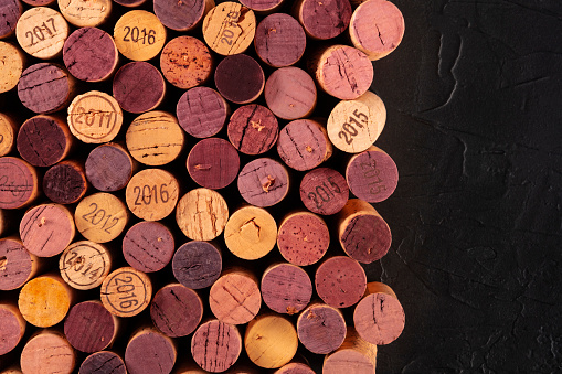 Wine corks background, a design template for a restaurant menu or winery brochure, shot from above with copy space on a dark background