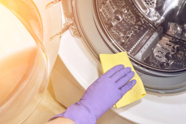 istock Hand in purple protective glove with rag. Cleaning washing machine 1224316619
