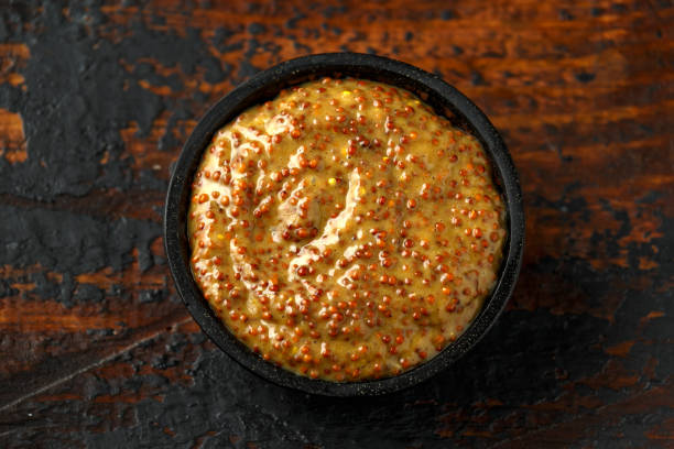 istock whole grain mustard in bowl on wooden table. 1224316747