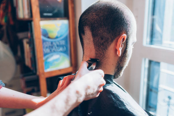 istock Woman barber cutting hair using razor 1224317679