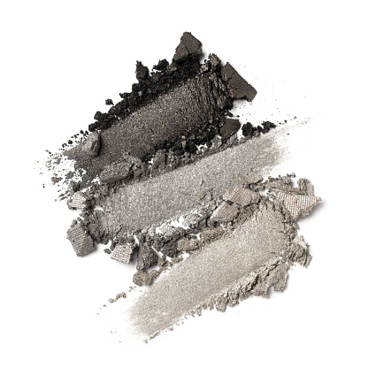Flat lay of brush strokes. Broken gray color eyeshadow as sample of cosmetic beauty product isolated on white background