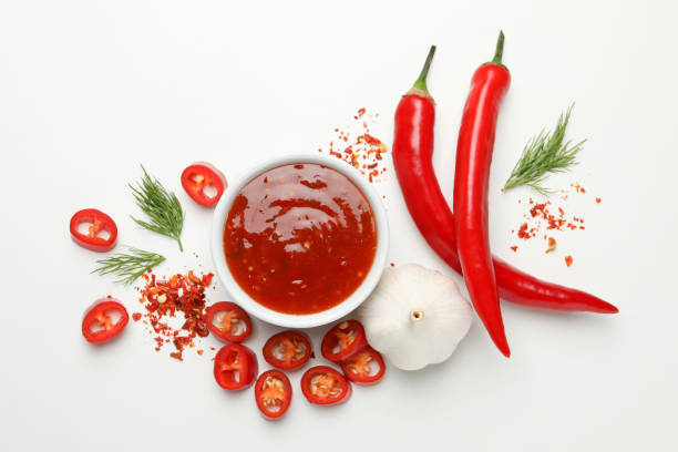 istock Bowl with chilli sauce, pepper and garlic on white background 1224319535