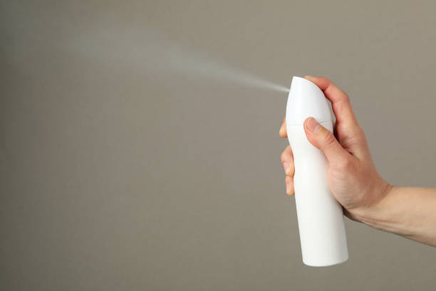 istock Woman spraying deodorant on gray background, space for text 1224322391