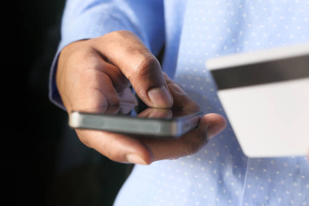 istock Man holding credit card and using smart phone, online shopping concept 1224323044