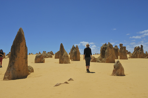 Australian woman hiking at wild landscape view of the pinnacles desert near Perth in Western Australia. The desert contain thousands of limestone formations called pinnacles