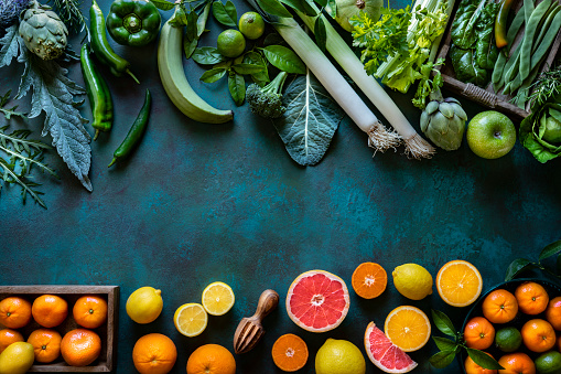 Vegetables and fruits vegan food assorted arrangement varied leaving green copy space background
