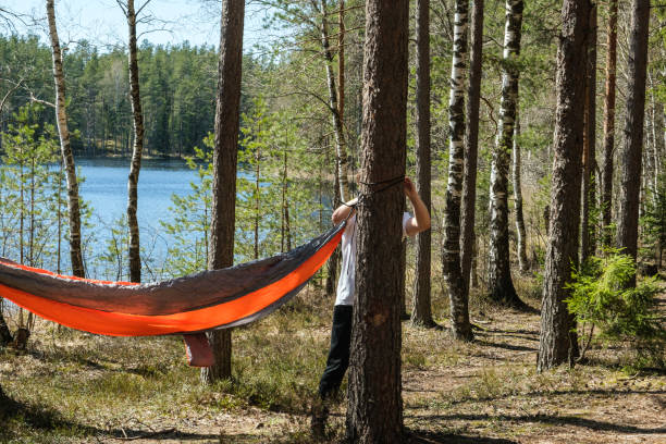 istock guy ties hammock forest between trees holiday sunny 1224327469