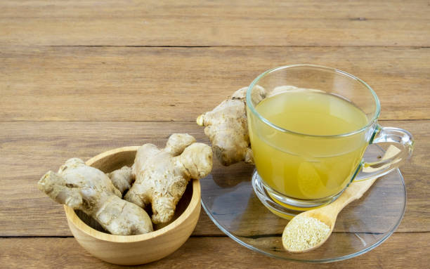 Ginger. Ginger and ginger tea in a cup on a wooden table at home. ginger stock pictures, royalty-free photos & images