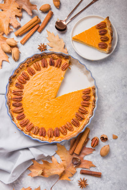 istock Pumpkin Pie and slice  with pecan nut and cinnamon on gray concrete background, top view, copy space. Homemade autumn pastry for Thanksgiving 1224330489