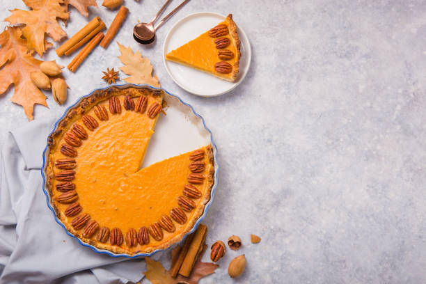 istock Pumpkin Pie and slice  with pecan nut and cinnamon on gray concrete background, top view, copy space. Homemade autumn pastry for Thanksgiving 1224330519