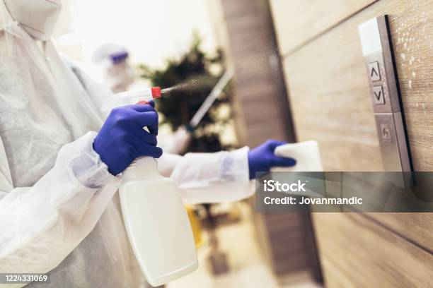 Staff Using Disinfectant From The Bottle Spraying An Elevator Push Button Control Panel Disinfection Cleanliness And Healthcareanti Corona Virus Stock Photo - Download Image Now