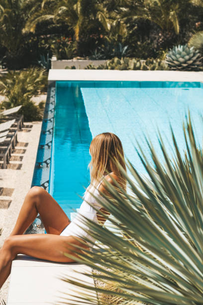 istock Woman relaxing by the pool 1224332025
