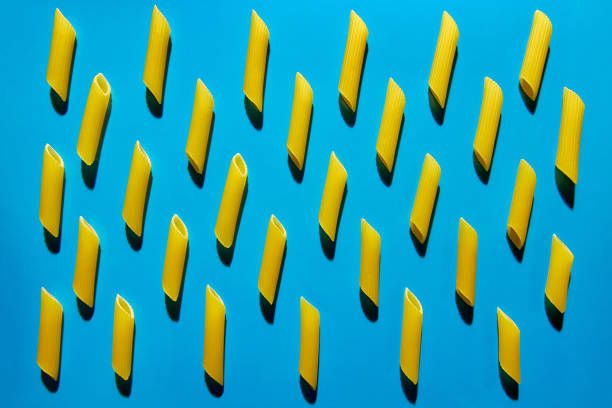 istock Yellow pasta on a blue background in hard light. Flat lay from macaroni 1224332066