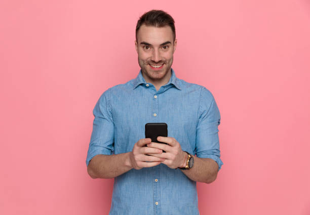istock businessman texting on his phone, smiling and looking at camera 1224332314