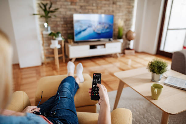 istock Laid back senior woman drinking coffee and watching television 1224335724