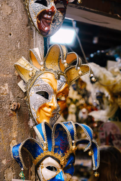 weneckie maski są tradycyjnym symbolem corocznego weneckiego karnawału. sprzedawane w oknie sklepu z pamiątkami w wenecji. trzy maski harlequin z czerwonego, złotego i niebieskiego. - venice italy mask harlequin venice carnival zdjęcia i obrazy z banku zdjęć