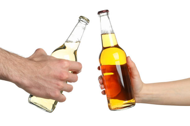 istock Hands hold bottles of cider, isolated on white background. Cheers 1224336340