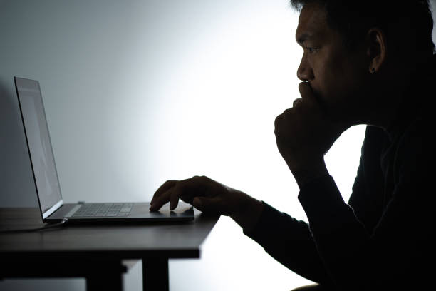 istock Silhouette asian man Working on Laptop. Beared man Works from home on Notebook. Freelancer man Blogger Working remotely at Home With Laptop. A Man looking and thinking face. 1224338154