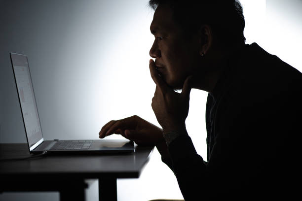 istock Silhouette asian man Working on Laptop. Beared man Works from home on Notebook. Freelancer man Blogger Working remotely at Home With Laptop. A Man looking and focusing face. 1224338198