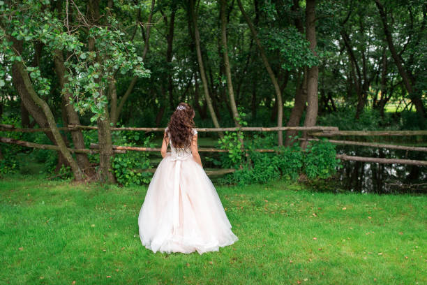 istock Beautiful bride stands with her back in a green meadow 1224338711