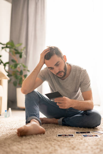 istock Lonely man watching photos 1224338776
