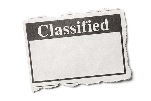 Classified Headline on a Torn Piece of Newspaper with White Background.