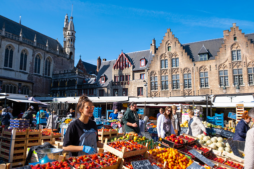 View of the Open Air Market in Burg Square in Bruges. Burg Square is one of the most prominent tourist spots in Bruges. There are the fourteenth-century City Hall, the Palace of the Liberty (Brugse Vrije), the old Court of Justice and the Basilica of the Holy Blood.