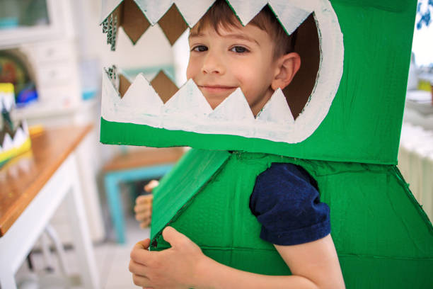 istock Smiling boy wearing a cardboard dinosaur costume 1224343369