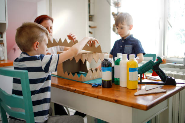 istock Mom and kids making a cardboard dinosaur costume 1224343566