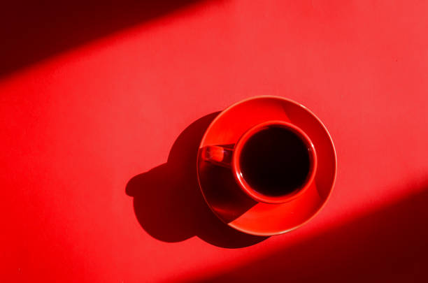 istock Red cup of coffee with shadows on red background in natural sunlight. 1224346790