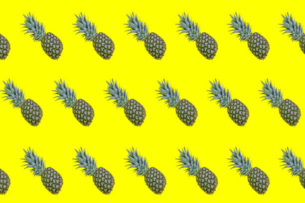 istock Large pattern of ripe pineapples on a yellow background 1224347672