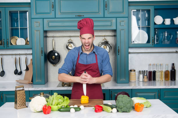 istock Macho with angry face cut pepper with knife 1224351675