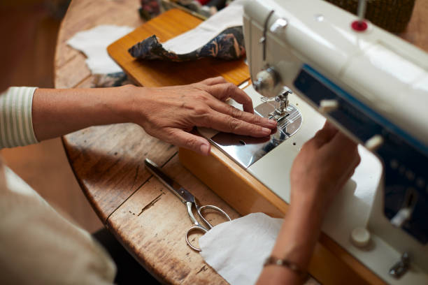 istock High angle close up view of hands working with a sewing machine. 1224356010