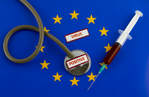 Stethoscope and syringe on EU flag with virus label
